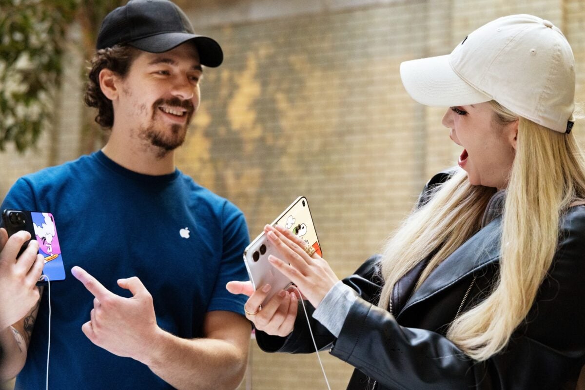 Apple-Covent-Garden-London-team-member-helps-customer-with-iPhone-Duo-261023_big.jpg.large_2x