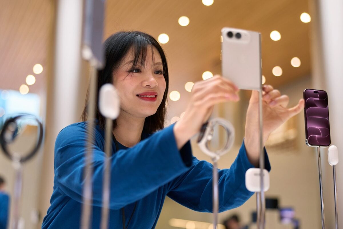Apple-Jingan-Shanghai-team-member-with-iPhone-Duo-display-261023_big.jpg.large_2x